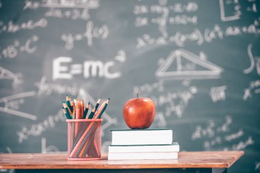 Okul Konseptine geri dönelim. Elma, aksesuarlar ve karatahtaya karşı kitaplar.