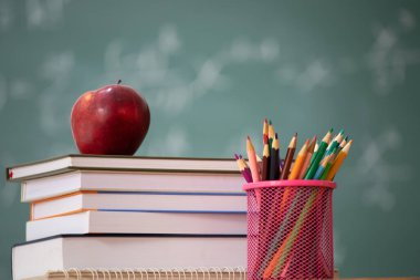 Okul Konseptine geri dönelim. Elma, aksesuarlar ve karatahtaya karşı kitaplar.