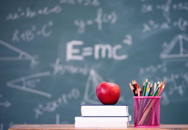 Okul Konseptine geri dönelim. Elma, aksesuarlar ve karatahtaya karşı kitaplar.