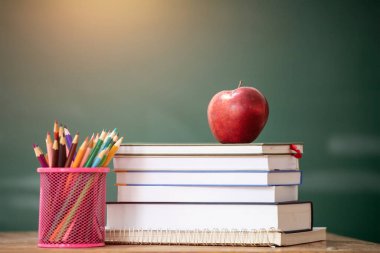 Okul Konseptine geri dönelim. Elma, aksesuarlar ve karatahtaya karşı kitaplar.