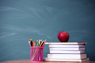 Okul Konseptine geri dönelim. Elma, aksesuarlar ve karatahtaya karşı kitaplar.