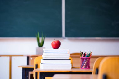 Okul Konseptine geri dönelim. Elma, aksesuarlar ve kitaplar sınıfta karatahtaya karşı..