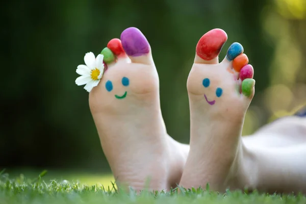 Piedi Bambino Dipinti Con Colorata Faccia Sorridente Erba Verde — Foto Stock