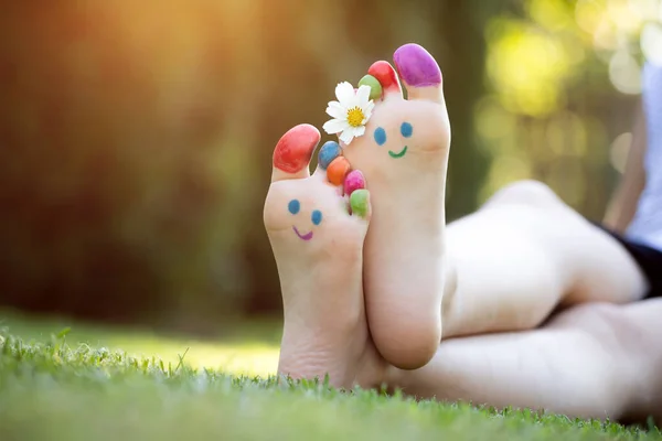 Dětské Nohy Malované Barevným Úsměvem Tvář Zelené Trávě — Stock fotografie
