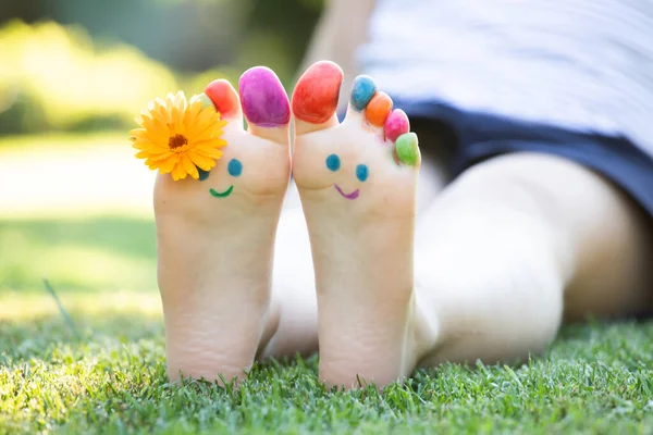 Piedi Bambino Dipinti Con Colorata Faccia Sorridente Erba Verde — Foto Stock