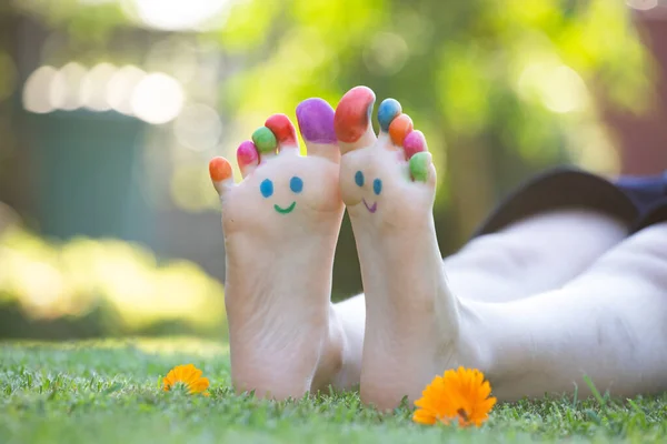 Child Feet Painted Colorful Smiling Face Green Grass — Stock Photo, Image