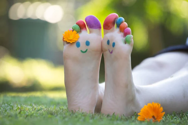Child Feet Painted Colorful Smiling Face Green Grass — Stock Photo, Image