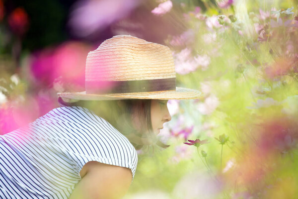 Adorable little girl having fun in summer flower garden.