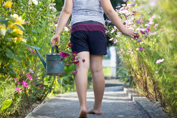 小女孩的腿和浇水可以在美丽的夏季花圃里 儿童园艺 — 图库照片