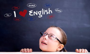 Dil eğitimi, İngilizce konsepti. Gözlüklü küçük kız yukarıda İngilizce yazıları seviyorum..