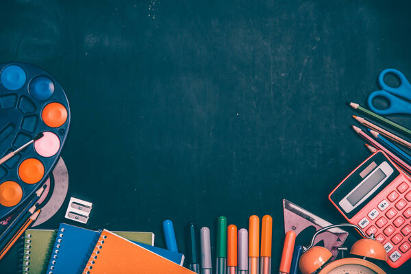 Education, back to school concept. School supplies on blackboard with copy space.