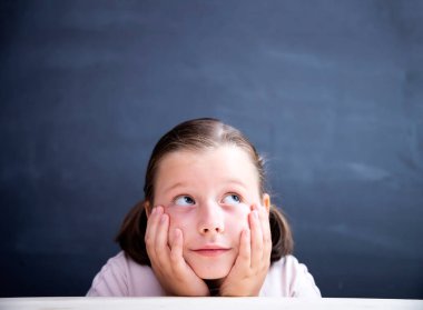  Telif uzayına bakan tatlı küçük kız tahtada arka planda