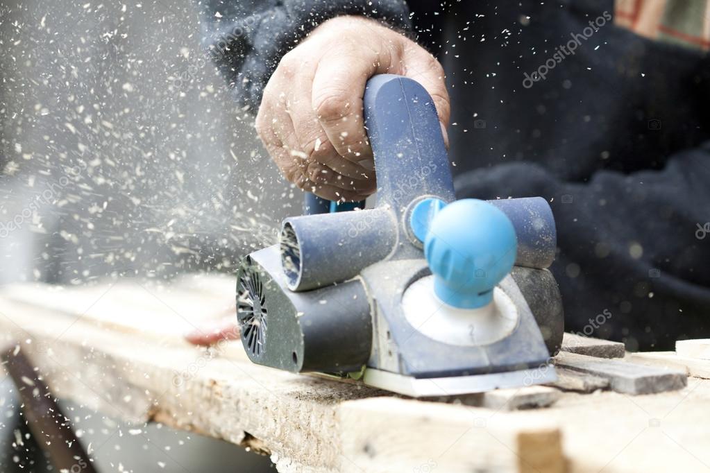 Carpenter sawing wood board