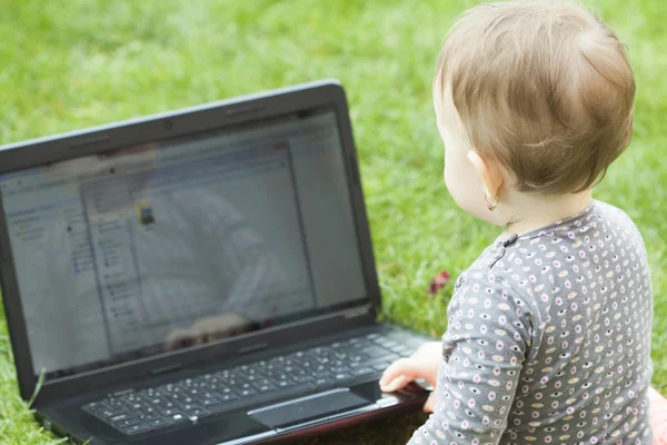 Schattige babymeisje met behulp van een laptop — Stockfoto