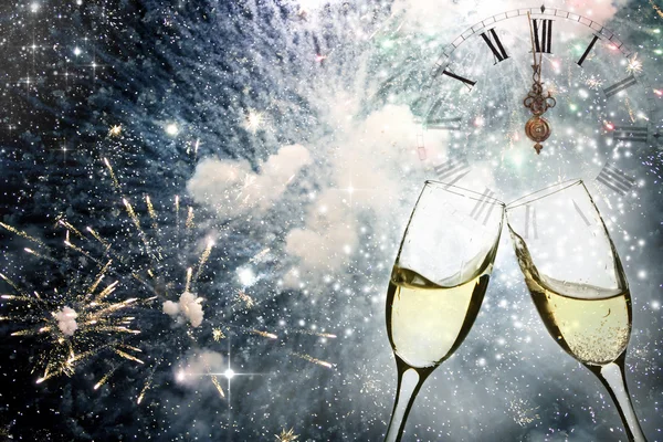 Glasses with champagne against fireworks and clock — Stock Photo, Image
