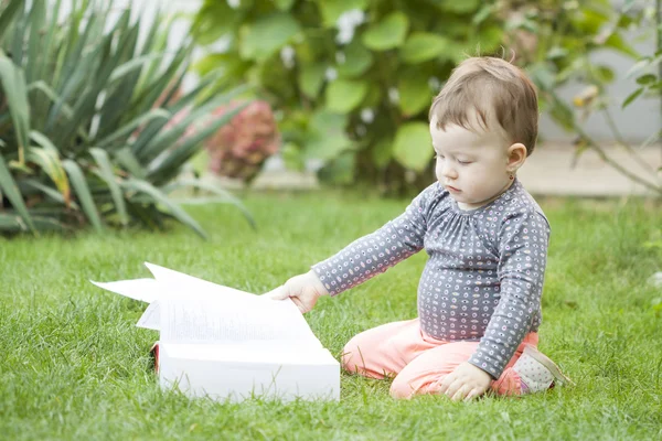 Mädchen schaut sich Buch an — Stockfoto