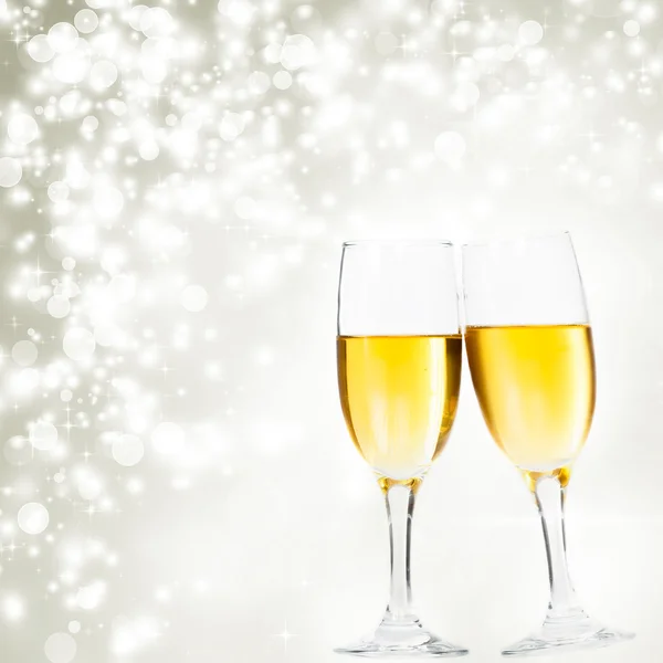 Champagne glasses against holiday lights — Stock Photo, Image