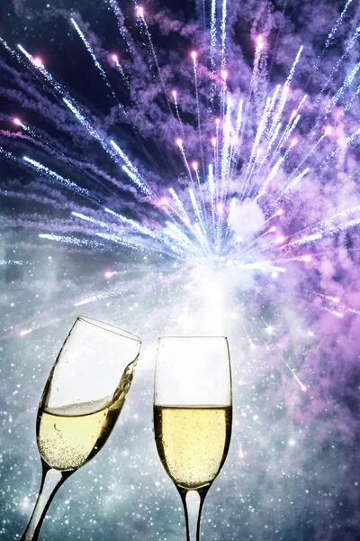 Champagne glasses against holiday lights and fireworks — Stock Photo, Image