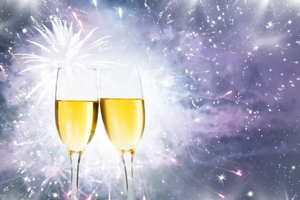 Champagne glasses against holiday lights and fireworks — Stock Photo, Image