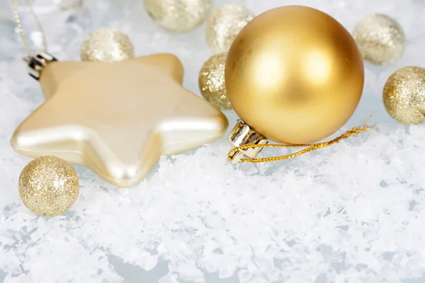 金色圣诞球和冰冷的背景上的明星 — 图库照片