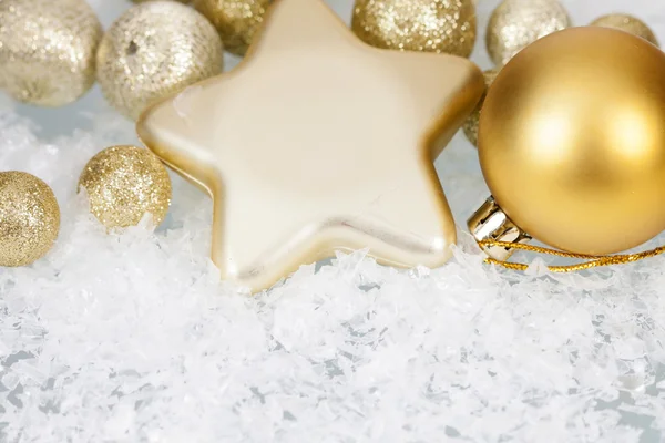 Gouden kerstballen en ster op ijzige achtergrond — Stockfoto