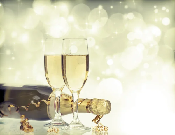 Vasos con champán y botella sobre fondo navideño —  Fotos de Stock