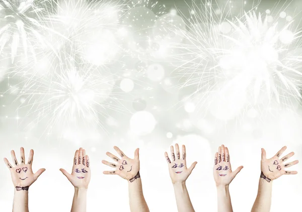 Painted palms with smiling faces celebrating New Year — Stock Photo, Image