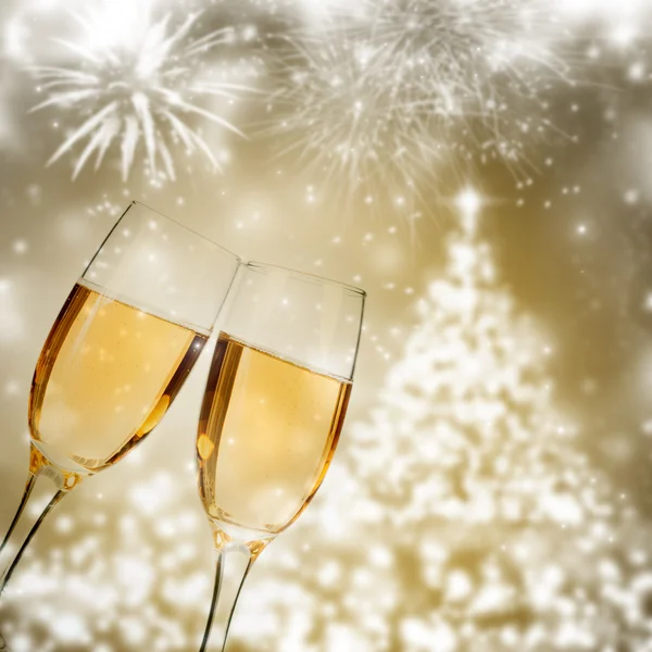 Glasses with champagne against fireworks — Stock Photo, Image