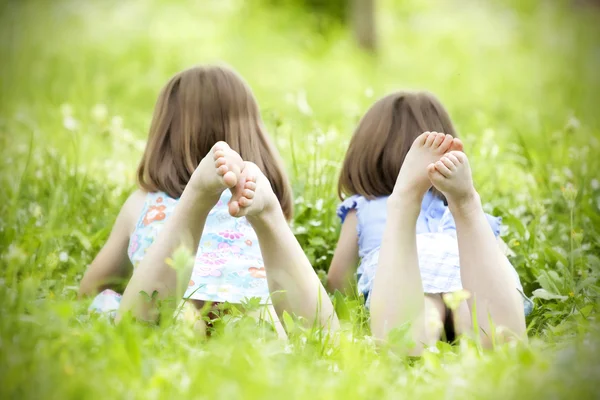 Meninas deitadas na grama verde — Fotografia de Stock