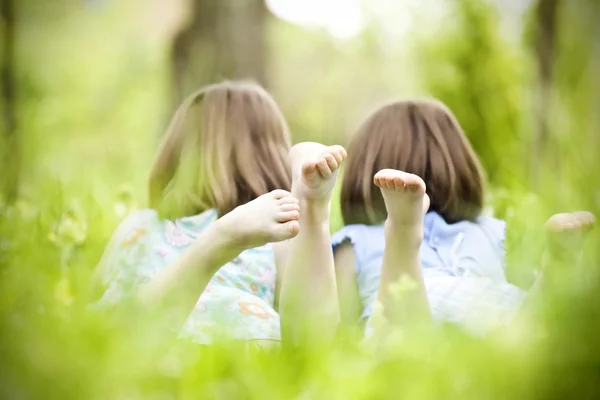 Meisjes liggend op groen gras — Stockfoto