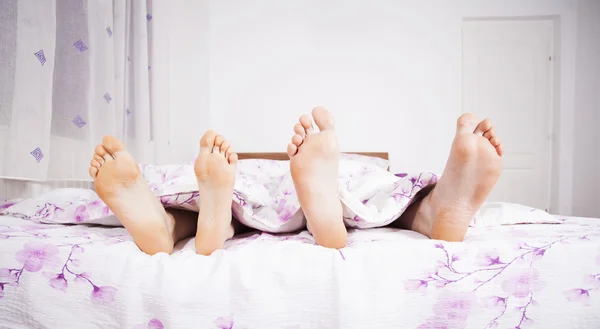 Füße eines Paares, das nebeneinander schläft — Stockfoto