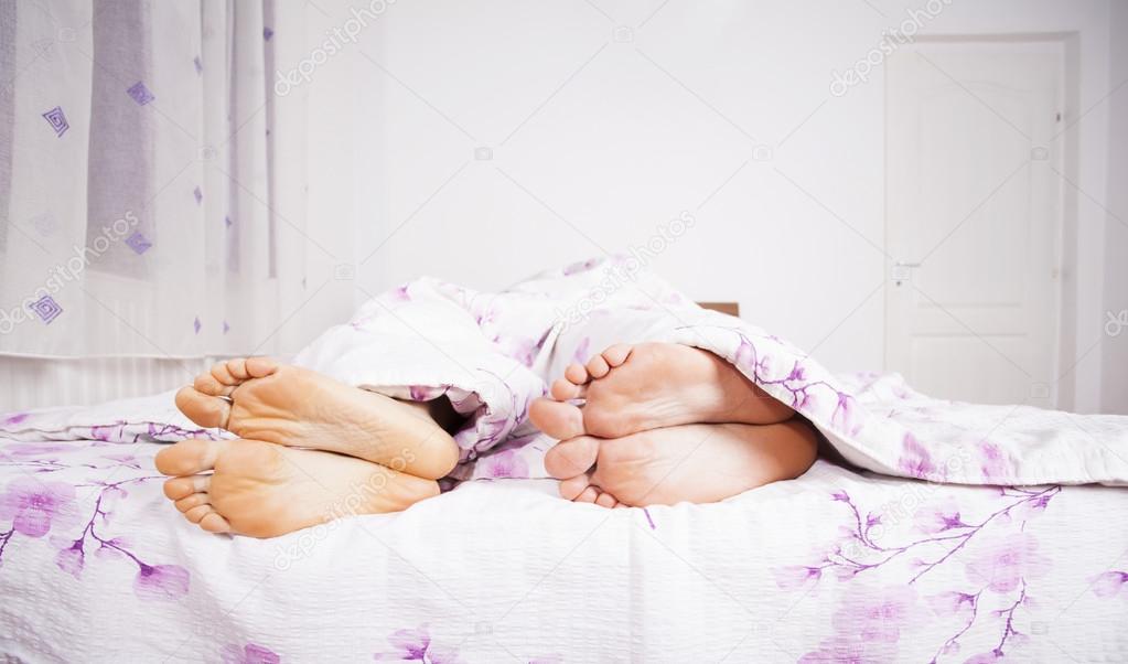 Feet of a couple sleeping side by side