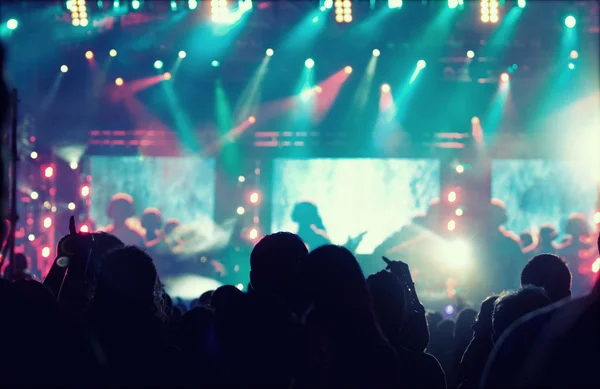 Animando a la multitud frente a las luces del escenario — Foto de Stock