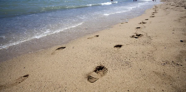 Voetstappen in het zand aan het strand — Stockfoto