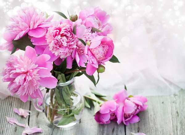 Ahşap arka planda pembe şakayıklar