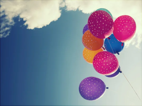 Kleurrijke ballonnen vliegen op de blauwe hemel — Stockfoto