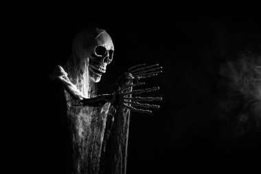 Creepy skeleton figure with skull in the dark. Halloween concept.