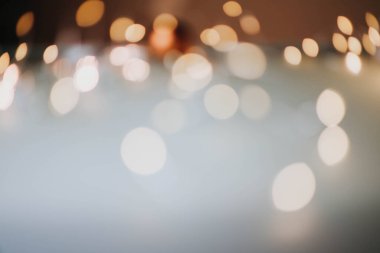 Sıcak turuncu, kahverengi tonlar ve bokeh efektiyle soyut bulanık arkaplan. Noel, tatil ışıkları.