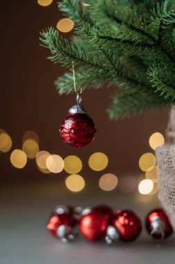 Kahverengi arka planda altın tatil ışıkları olan kırmızı Noel topları