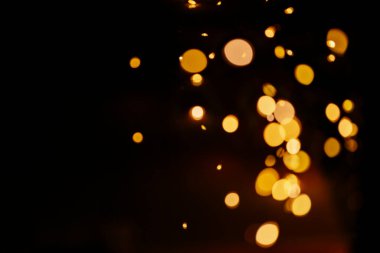 Sıcak turuncu, kahverengi tonlar ve bokeh efektiyle soyut bulanık arkaplan. Noel, tatil ışıkları.