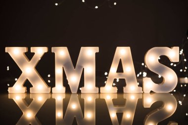 Bokeh arka planında parlayan eski ampullü XMAS harfleri.
