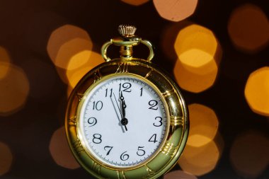 Yılbaşı geceyarısı - Altın tatil ışıkları üzerindeki eski saat