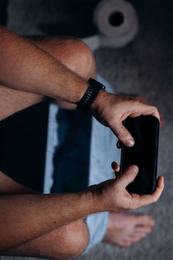 Tuvaletteki klozetin üzerinde akıllı telefonunu kullanan beyaz bir adam. Bağımlılık, sosyal ağa bağımlılık.