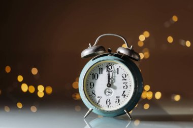 Yılbaşı geceyarısı, altın renkli tatil ışıkları olan eski saat. Fotokopi alanı olan şenlikli parti davetiyesi