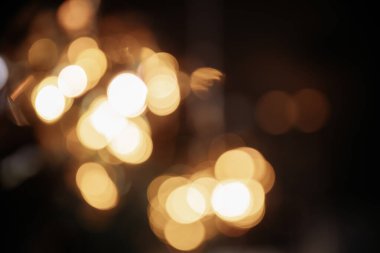 Sıcak turuncu, kahverengi tonlar ve bokeh efektiyle soyut bulanık arkaplan. Noel, tatil ışıkları.