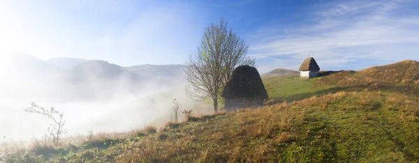 Pequeña casa de campo en las montañas en la niebla de la mañana —  Fotos de Stock