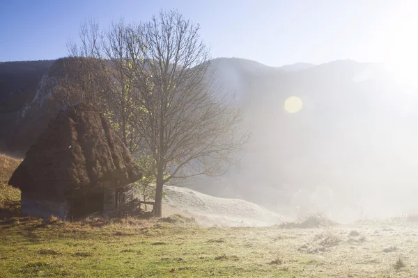 Kleines Ferienhaus in den Bergen im Morgennebel — Stockfoto