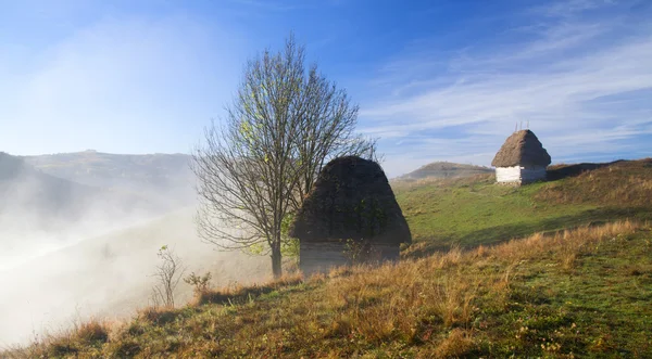 Petit chalet dans les montagnes dans le brouillard du matin — Photo