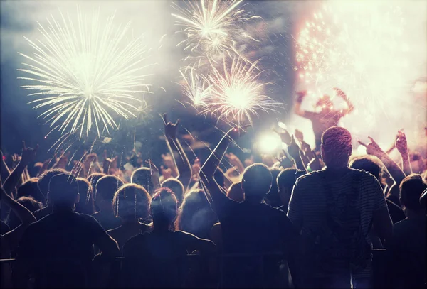 Multitud celebrando con fuegos artificiales — Foto de Stock