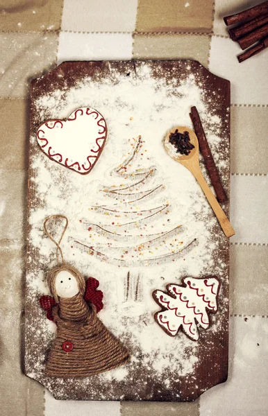 Galletas de Navidad, especias y harina sobre tabla de cortar de madera — Foto de Stock